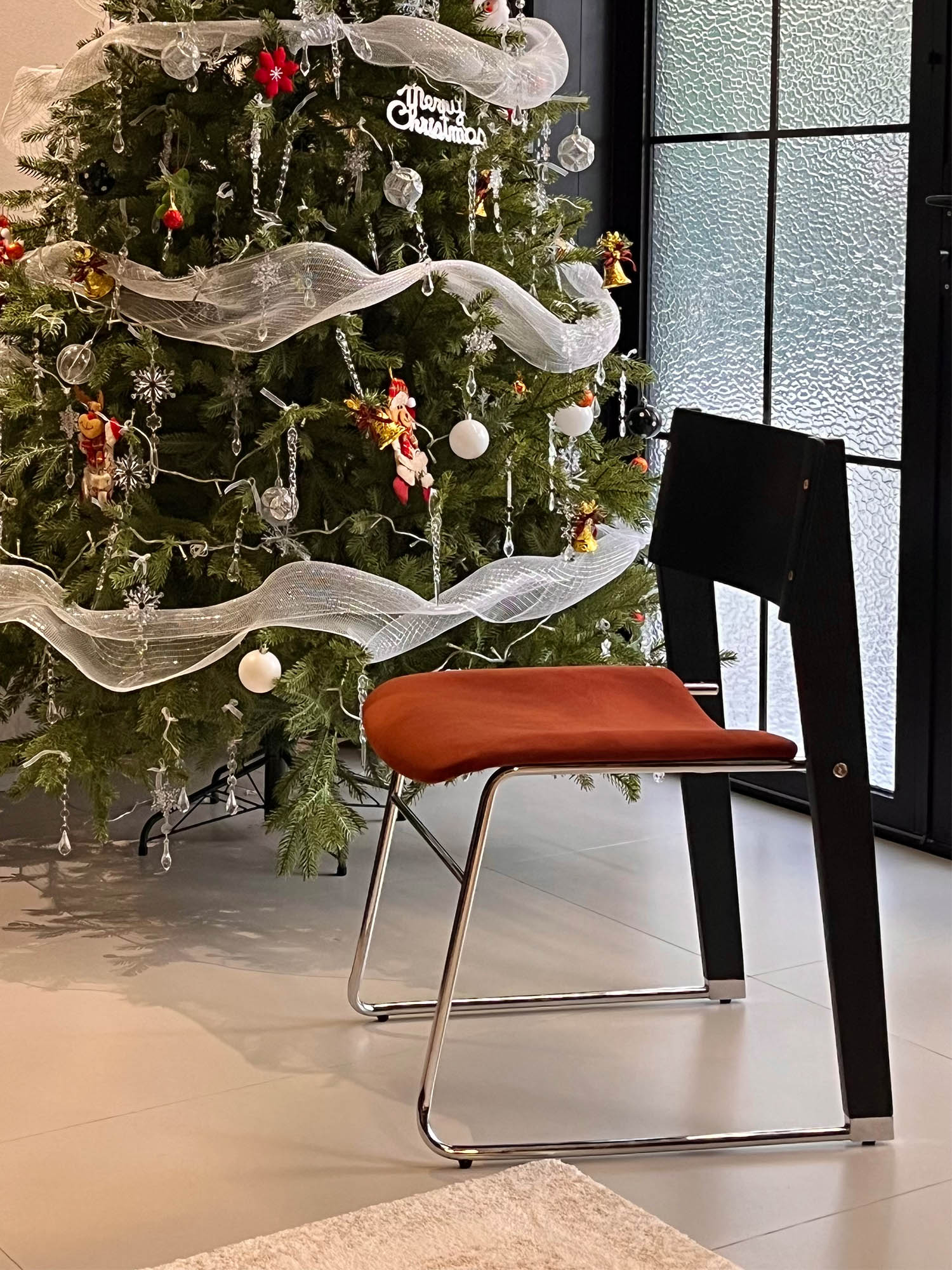 walk slowly chair 21 Walk Slowly Chair with rust velvet seat beside a decorated tree
