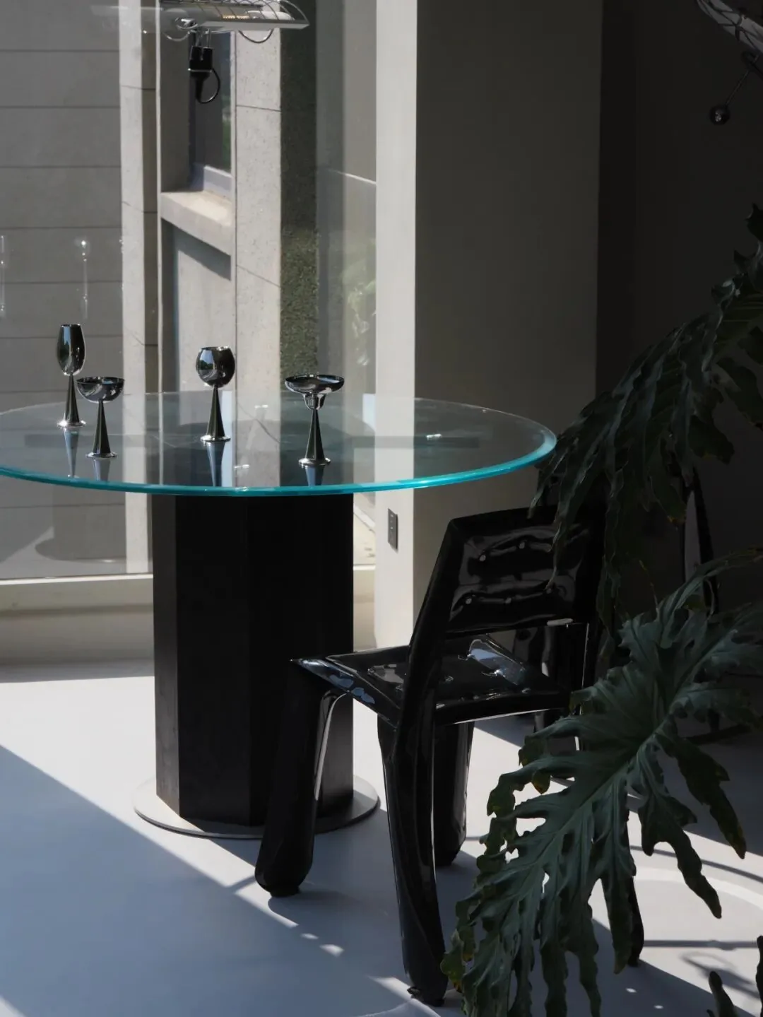 Furniture by the Window 15 Round glass dining table beside a window with a green view